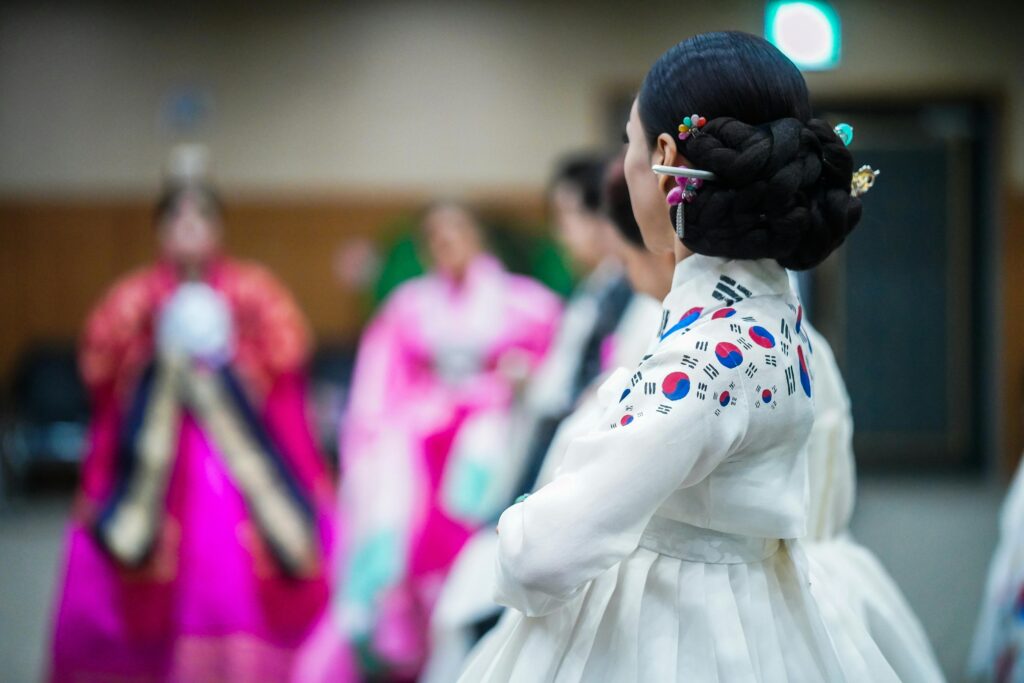 Elegant Korean woman in traditional hanbok during a cultural event indoors.