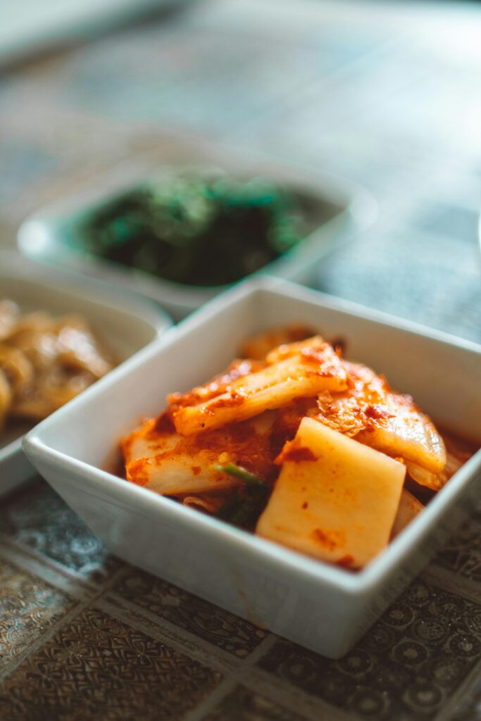 Close-up of spicy Korean kimchi in a ceramic bowl, showcasing traditional flavors and vibrant colors.