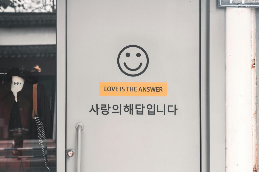 Grey door with a smiley face and 'Love is the Answer' text in English and Korean.