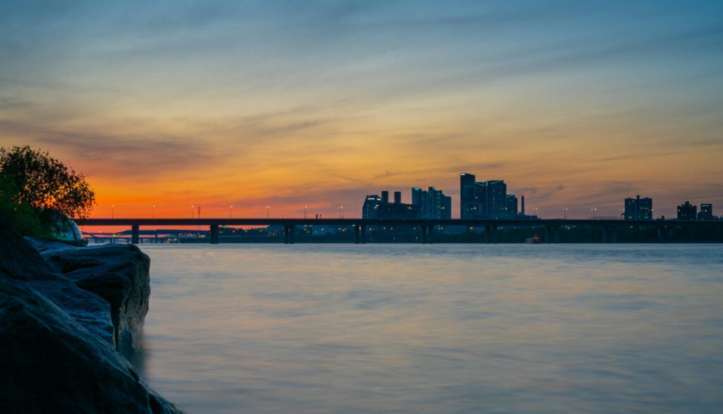 Stunning view of Seoul's skyline and river at sunset with a bridge in the foreground.