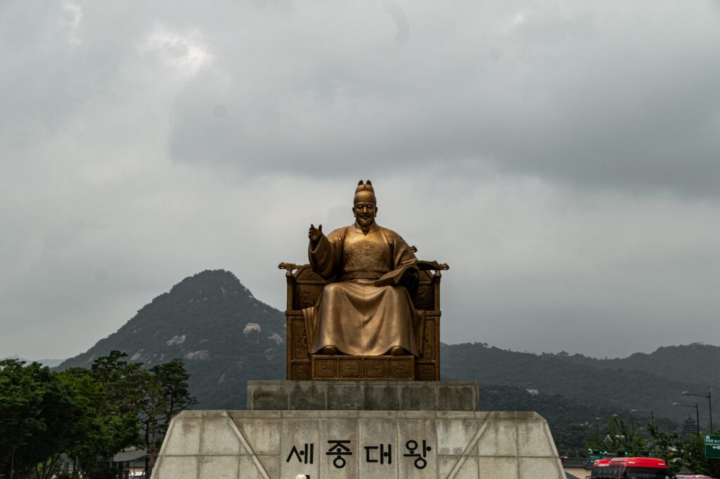 Majestic statue of King Sejong the Great in Seoul, South Korea with mountains in the background.